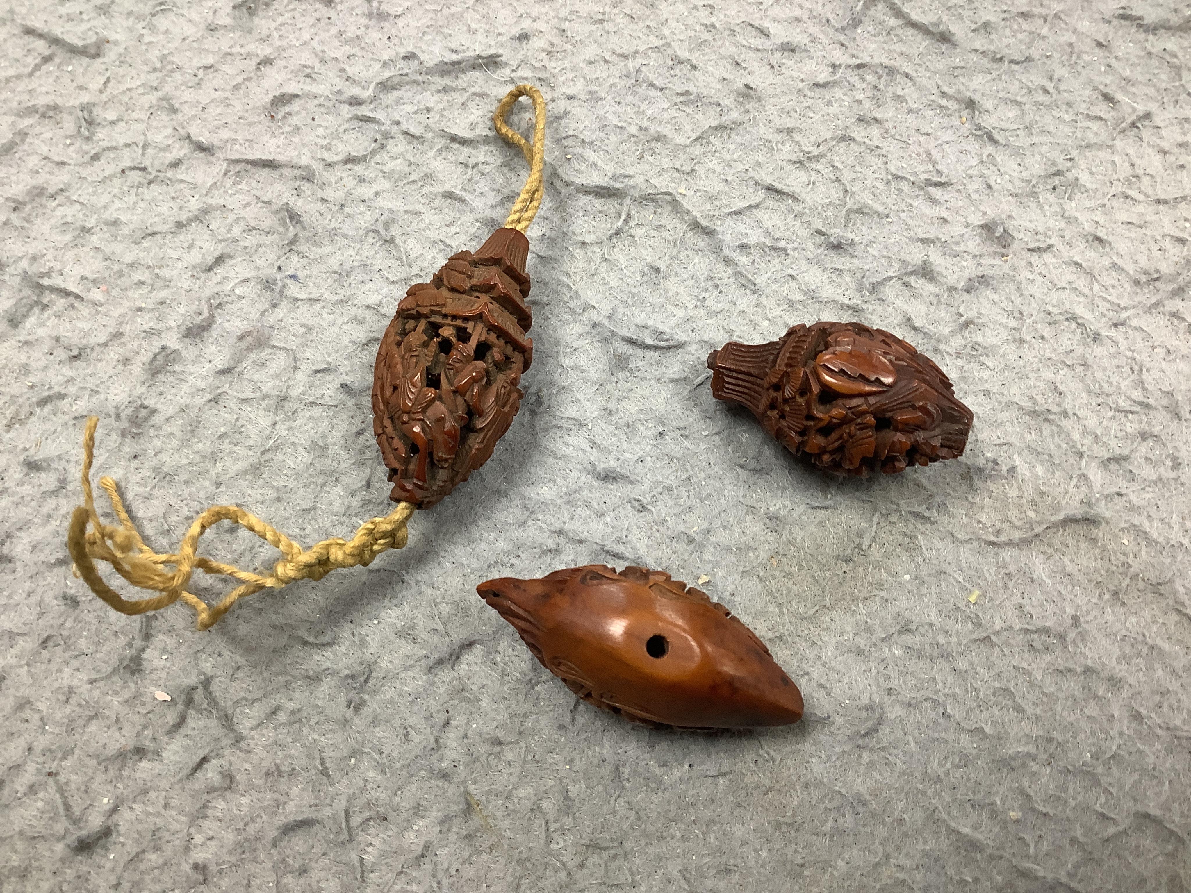 Four Chinese carved peach stones and an 18th/19th century Chinese carved wood cup, 6cm wide (5). Condition - fair to good